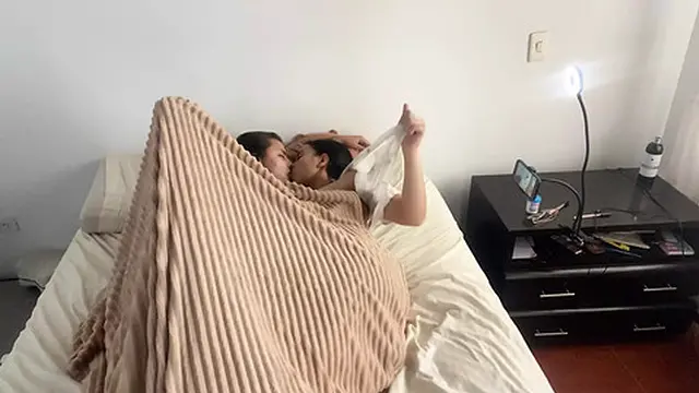 Lesbian intimacy under the sheets on a chilly morning