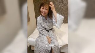 Older Japanese woman seductively undressing in traditional robe